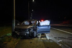 Wrecked car with alcohol bottles and cans on ground