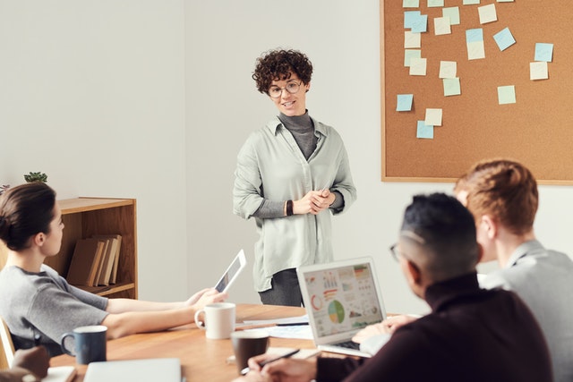 Lady standing up in meeting.