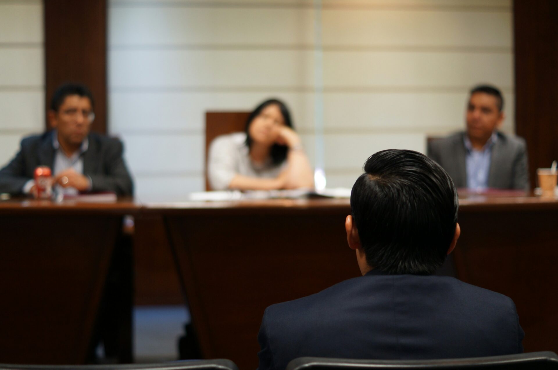 Person sitting in front of three lawyers